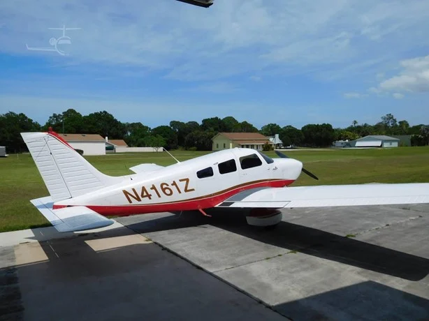 N4161Z Main - Countrywide Flyers | Orlando Apopka X04 Small white and red single-engine airplane parked on a concrete apron with a grassy field and houses in the background; registration N4161Z
