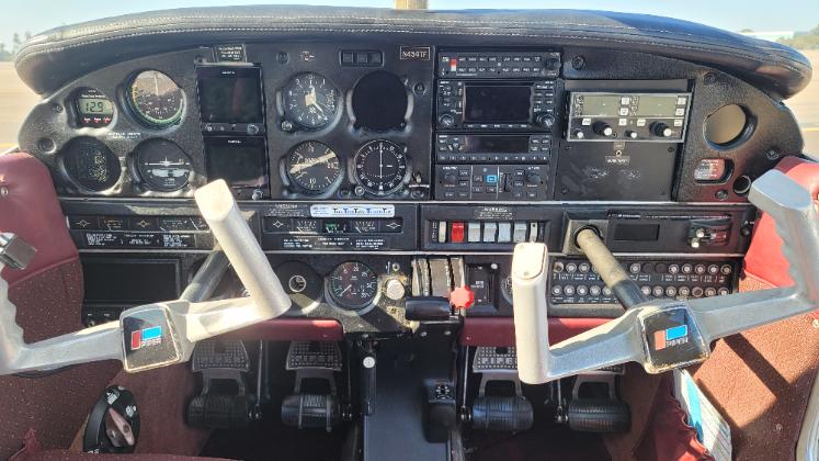 N4547F 13 - Countrywide Flyers | Orlando Apopka X04 Small airplane cockpit with dual control yokes, analog gauges, radios, and switches on the instrument panel, viewed from the pilot seat toward the windshield.